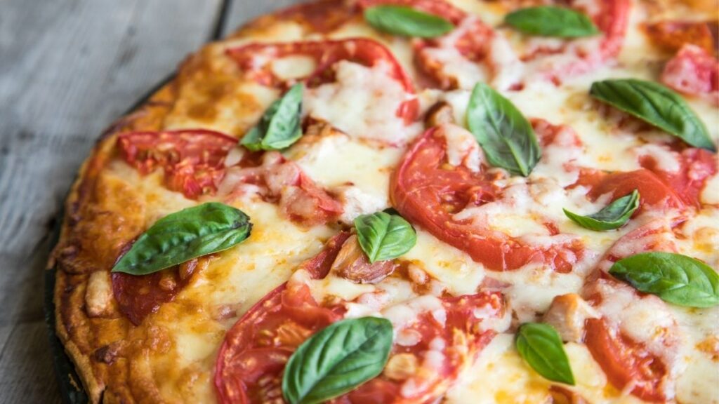 homemade pizza with tomatoes and fresh basil
