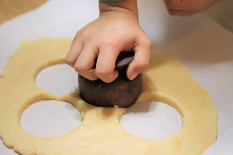 image of child's hand cutting out grapefruit shortbread cookies from rolled dough
