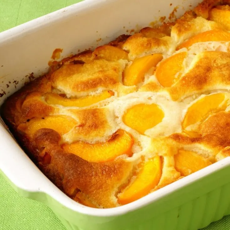 peach cobbler with canned peaches in a green baking dish