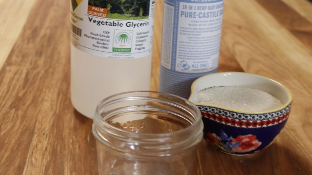 ingredients for diy hand scrub for gardeners on wooden table - glycerinf, castile soap, sugar, mason jar