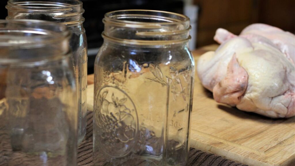canning jars in foreground and whole chicken in background