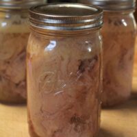 three mason jars of home canned chicken pieces